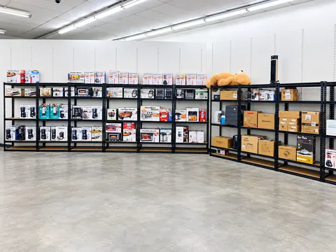 Black metal shelves stocked with boxed small appliances