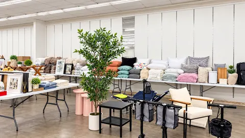 Tables of pillows, throws, framed art, and small furniture